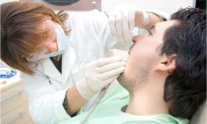 A dentist pulling out a patient's loose tooth.